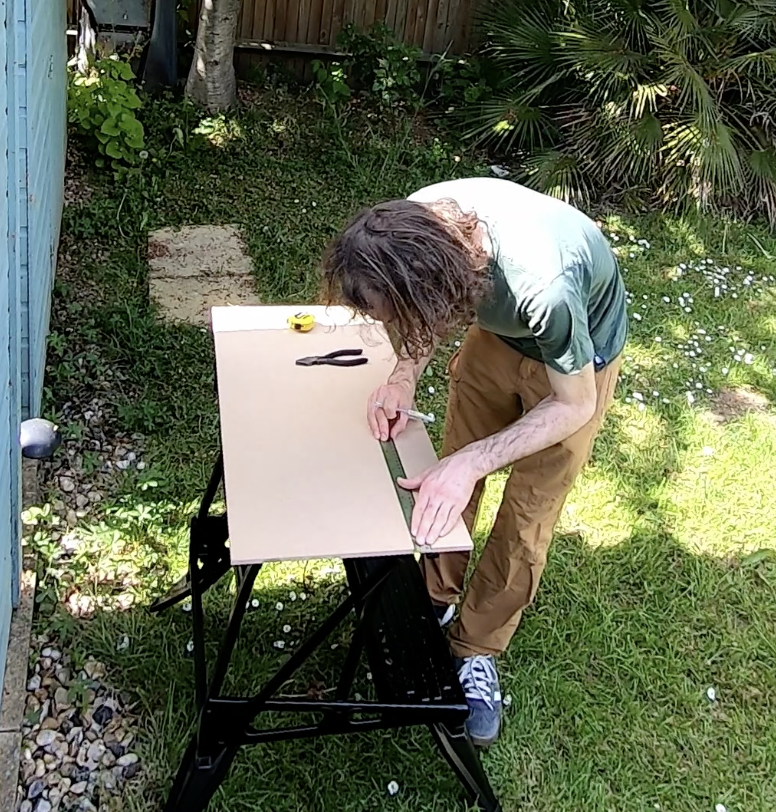 Photo of me measuring wood at a workbench,