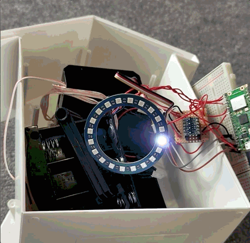 The disassembled clock, showing the LED light ring. The ring is rotating a red, green and blue test pattern.